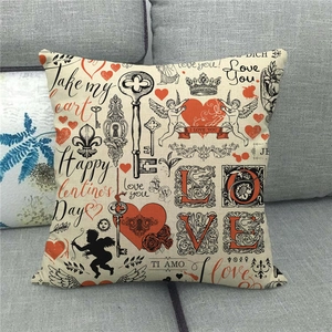 Close-up of linen pillowcase with vintage Valentine patterns on a grey sofa