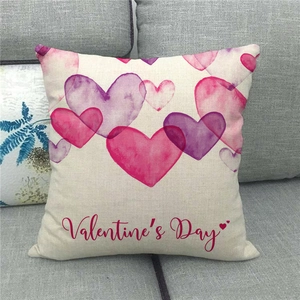 Close-up of linen pillowcase with watercolor hearts and Valentine's Day text on sofa