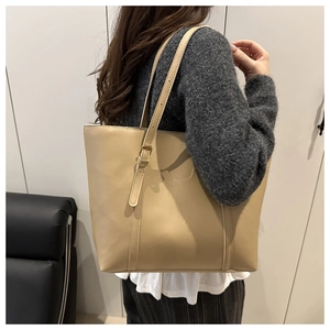 Détail de la boucle métallique réglable sur la bandoulière du sac cabas beige en cuir