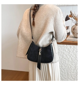 Detail view of contrast stitching and gold piston buckle on black hobo bag for women