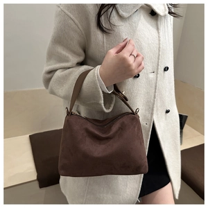 Detail of coffee suede tote bag with golden zipper and high-quality leather texture