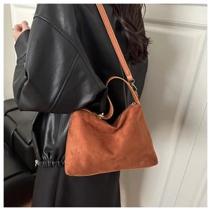 Close-up of brown frosted leather tote bag with gold hardware and adjustable strap