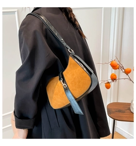 Detail of vintage crescent bag showing brown suede texture and gold piston clasp