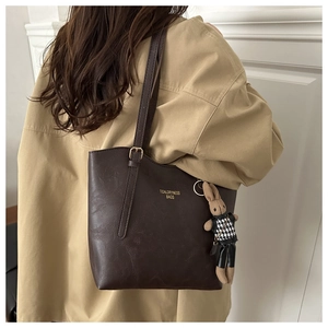 Deep brown textured PU leather tote bag with a cute plush rabbit charm and gold lettering