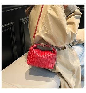 Detailed view of red woven herringbone texture and metallic clasp on pillow bag