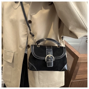 Detailed close-up of vintage black crossbody bag with suede leather and gold buckle
