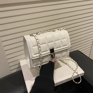 White quilted flap square crossbody bag with silver chain strap and metal lock