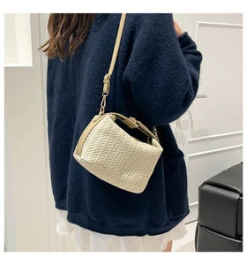 Close-up of cream woven shoulder bag featuring premium leather craftsmanship and gold hardware