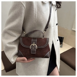 Detail of vintage contrast stitching and golden buckle on brown faux suede shoulder bag