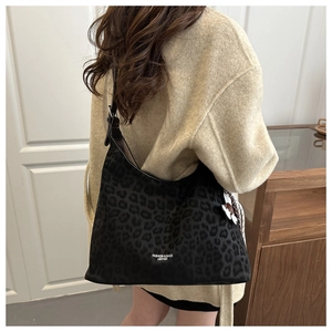 Détail du sac hobo vintage à imprimé léopard avec bandoulière et pendentif décoratif