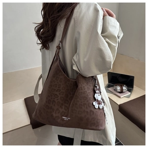Detail of leopard print suede tote bag with cute dog charm and logo print