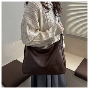 Detail einer großen dunkelbraunen Schultertasche aus Kunstleder mit lockerer Silhouette