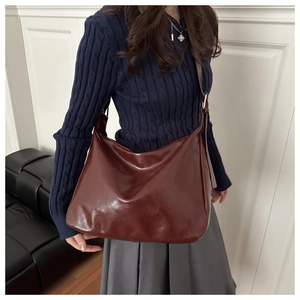 Sac bandoulière brillant bordeaux sur mannequin avec bandoulière réglable et grand volume