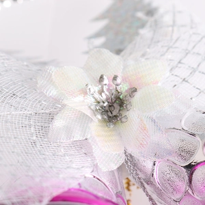 Macro detail of iridescent mesh bow with glittered floral center and silver bead accents