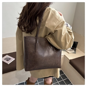 Deep brown vintage tote bag shown in a lifestyle commuter scene with a leather texture