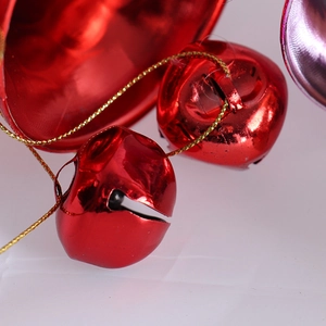 Macro shot of metallic red Christmas bells with glossy finish and golden hanging cords