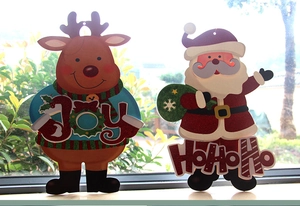 Dettaglio delle decorazioni di renna e Babbo Natale con glitter e scritte natalizie