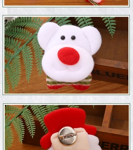 Detail of plush bear brooch featuring a red nose, striped bow, and metal safety pin