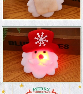 Close-up of Santa Claus LED glowing brooch with festive snowflake pattern on a wooden base