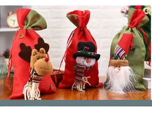 Close-up of drawstring Christmas gift bags with 3D plush Santa, Snowman and Reindeer