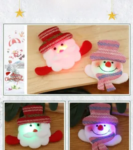 Detail of LED glowing Christmas brooches featuring Santa Claus and Snowman plush designs
