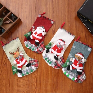 Detailed view of four Christmas stockings with 3D embroidery on rustic wooden background