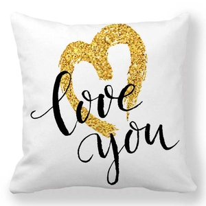 Detail of white square pillowcase with a gold glitter heart and black love you script
