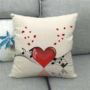 Linen pillowcase featuring red hearts and music notes on a grey fabric sofa