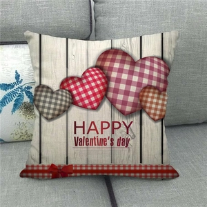 Linen Valentine's Day pillow cover with red plaid hearts and bow on a sofa