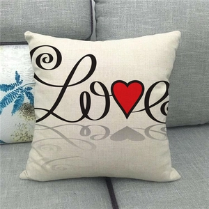 Detail view of linen blend pillow case featuring Love text and red heart on grey sofa