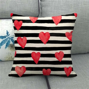 Detail of linen pillowcase with black and white horizontal stripes and red heart patterns