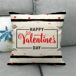 Detail of linen Valentine's Day pillow cover with red heart and stripes on grey sofa