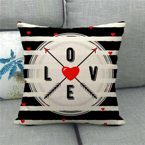 Close-up of linen pillowcase with black stripes and red heart LOVE graphic on a sofa