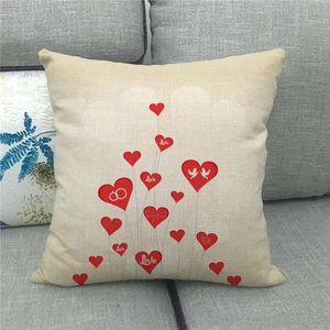 Close-up of linen pillowcase with red Love hearts on a grey fabric sofa