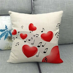Linen pillow cover with musical notes and red hearts on a gray fabric sofa setup