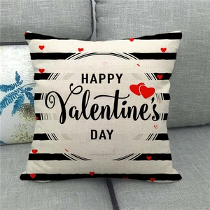 Close-up of Happy Valentine's Day linen pillow cover with red hearts on a gray sofa