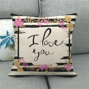 Close-up of linen pillow cover with I love you text and floral patterns on a sofa