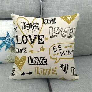 Close-up of linen Valentine's Day pillowcase with Love and Be Mine text on a gray sofa