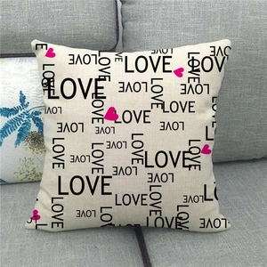 Detail shot of linen pillowcase with black LOVE print and pink heart on gray sofa