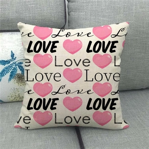 Linen pillow cover with pink hearts and LOVE print on a gray fabric sofa