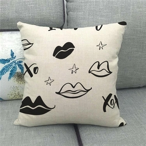 Close-up of linen cushion cover showing XO print and fabric texture on a gray sofa