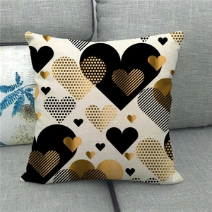 Linen Valentine heart pillow cover with black and gold patterns on a gray sofa