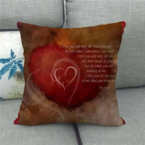 Macro detail of linen pillow cover featuring red heart pattern and vintage poem text