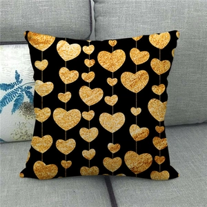 Detail of square black linen pillowcase with vertical gold sequin heart patterns