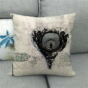 Close-up of linen cushion cover featuring industrial heart lock print on a grey sofa