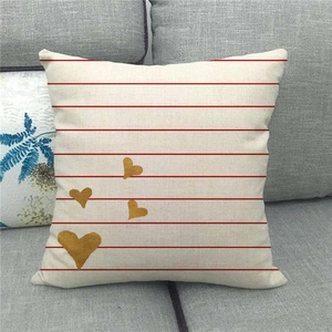 Close-up of linen cushion cover with red stripes and gold hearts on a sofa