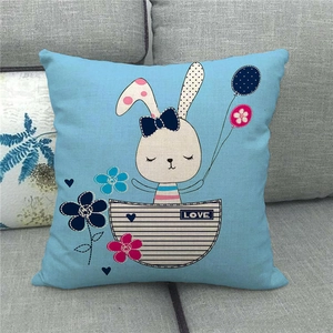 Detailed close-up of light blue linen pillow case with cute rabbit and LOVE design on a sofa