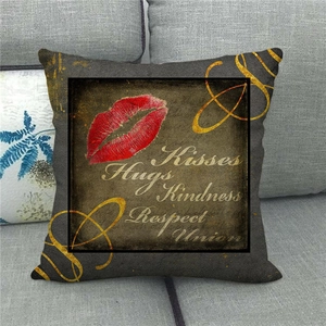 Close-up of linen pillow cover with red lips and golden artistic text on a sofa
