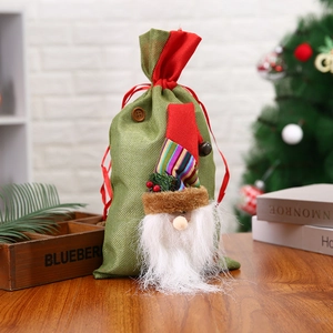 Christmas gift bag with 3D gnome design, green burlap fabric, and red drawstring closure