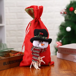 Red Christmas drawstring gift bag with 3D snowman mascot on rustic wooden background